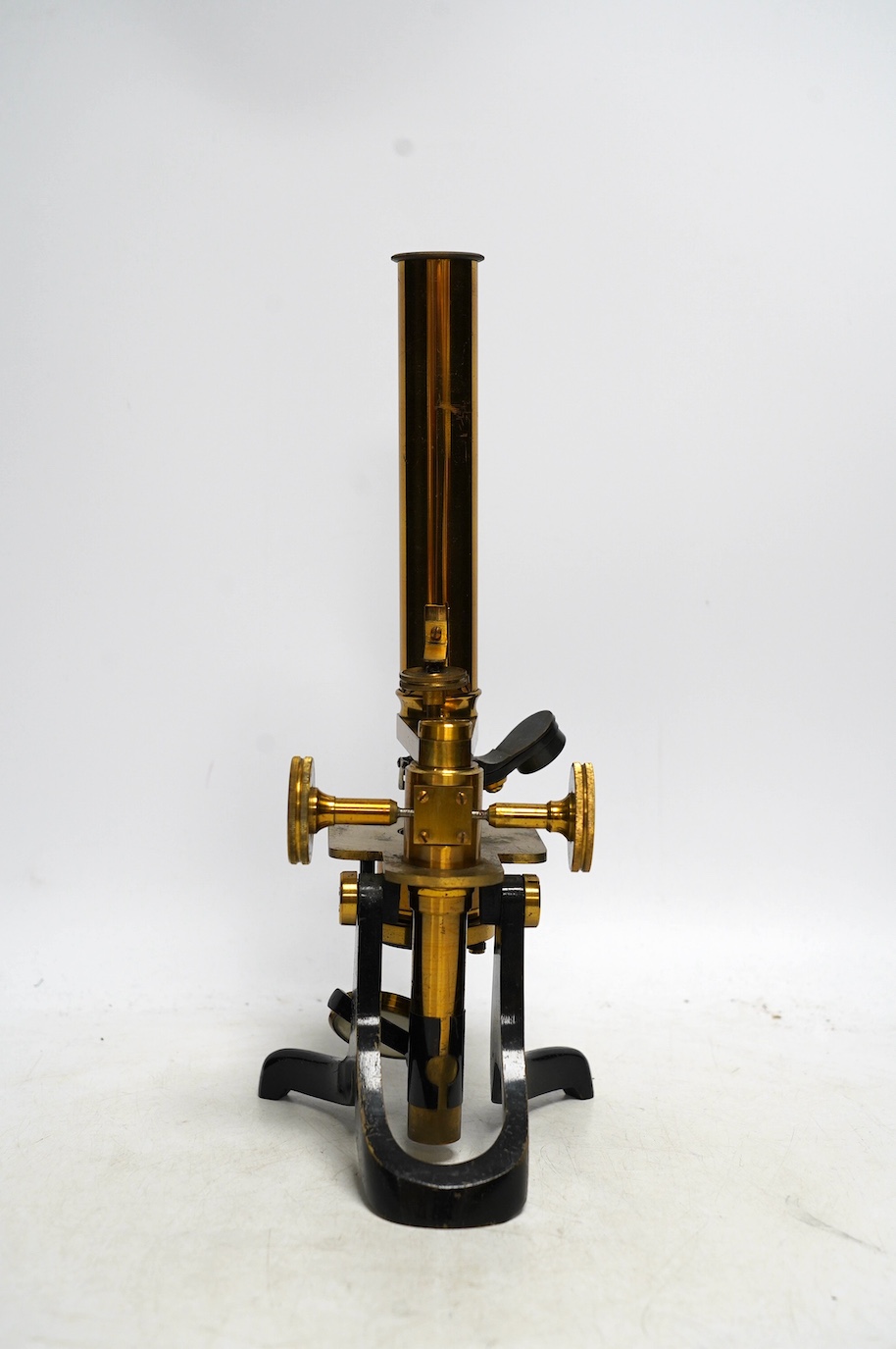 An unmarked late 19th century monocular brass microscope, in a fitted mahogany case with alternative lenses, a drawer for slides and other accessories, case 39cm high. Condition - fair to good